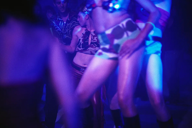 mulher dançando sensual no centro de uma balada liberal com luzes vibrantes e clima provocante